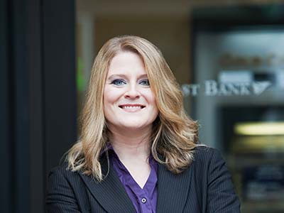 Bank teller outside bank.