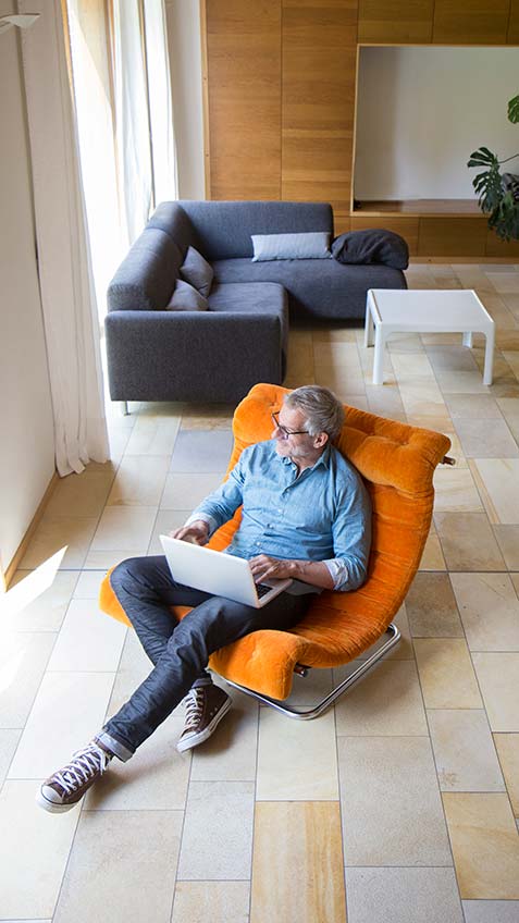 Man sitting in chair working remotely.