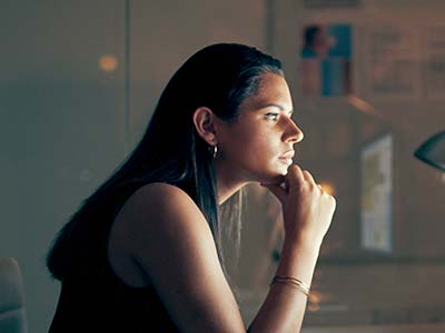 Businesswoman using a computer at night in a modern office