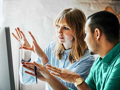 Team members talking in front of a computer screen.