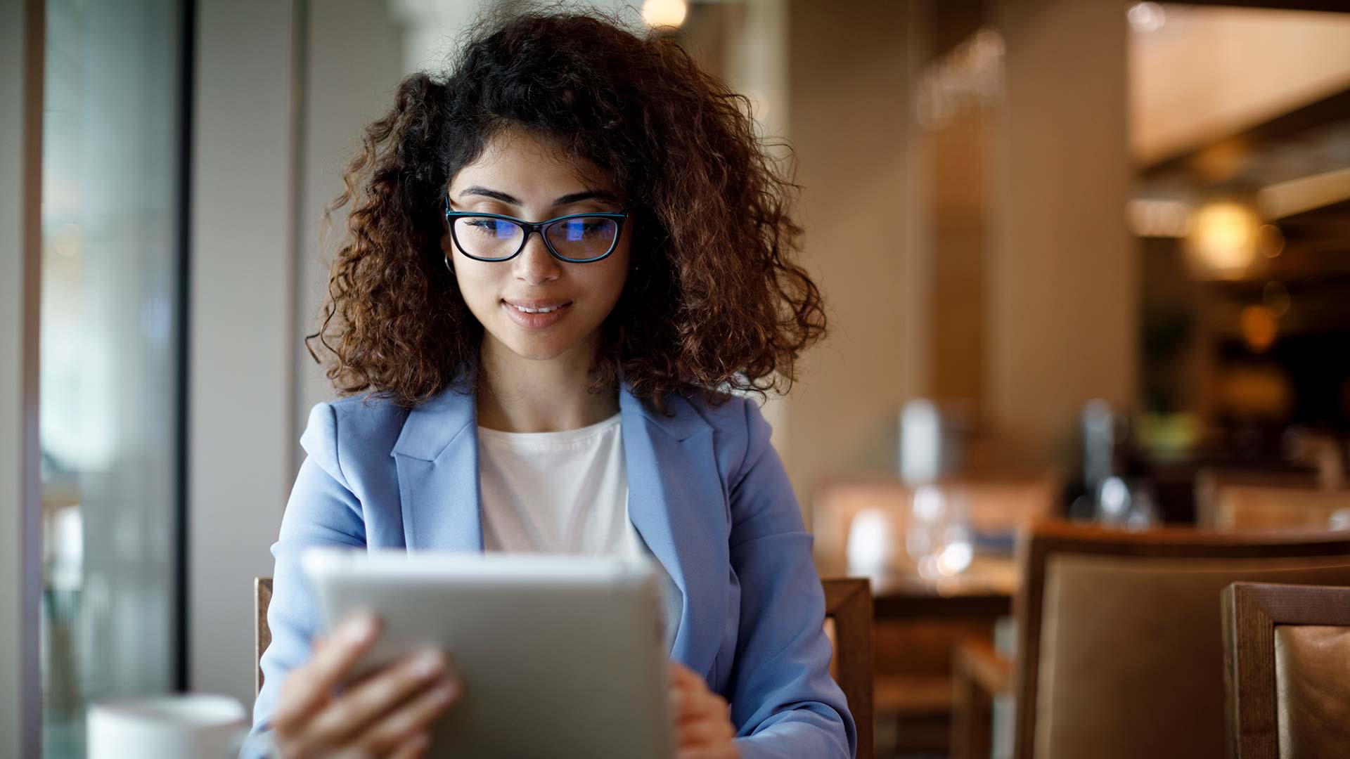 Businesswoman using digital tablet at a cafe.