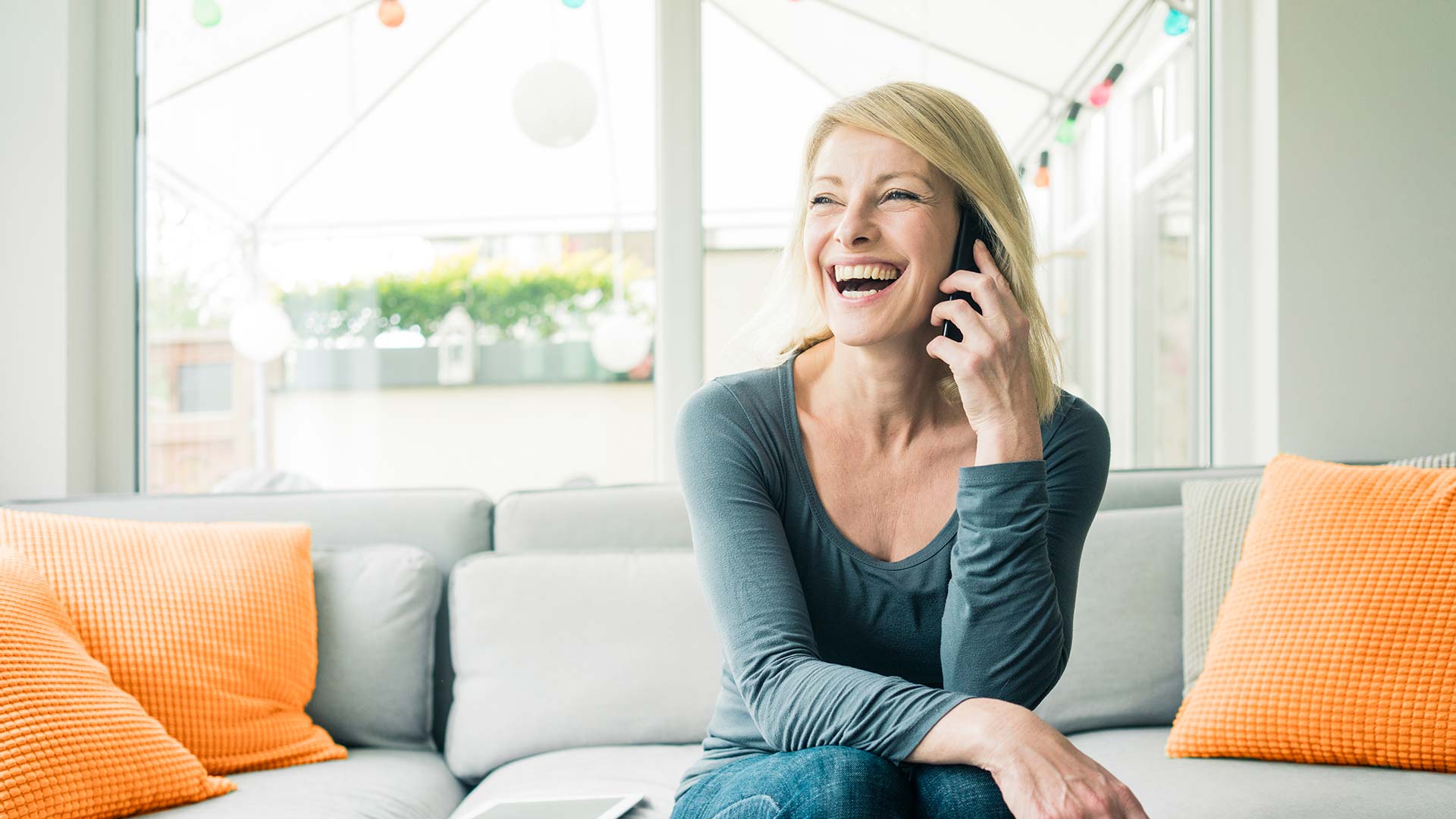 Woman on phone laughing.