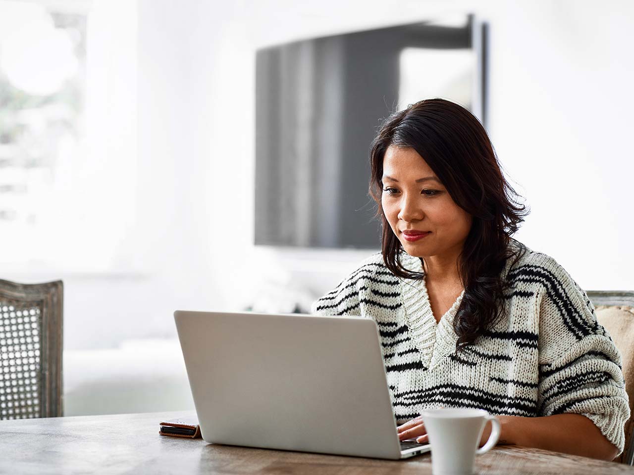 Woman on a computer in her house.