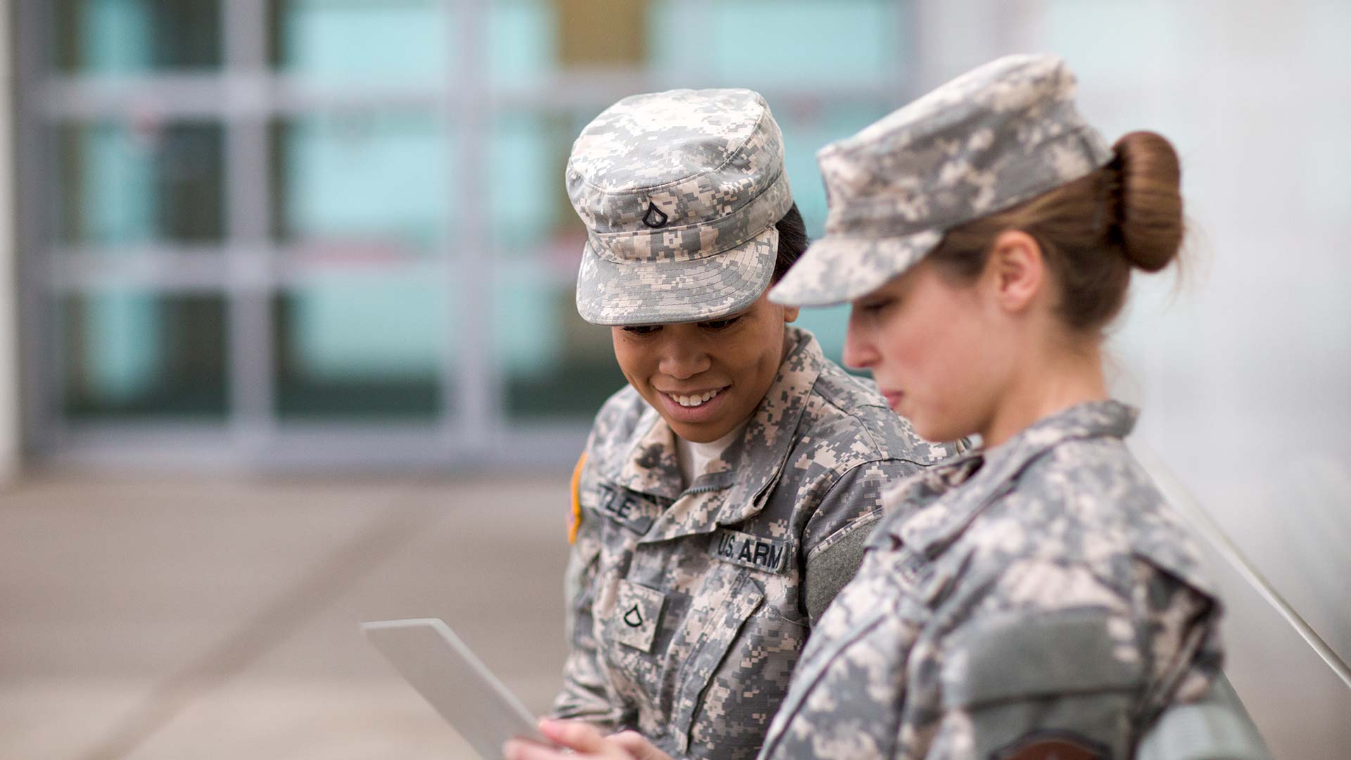 Two soldiers looking at a tablet