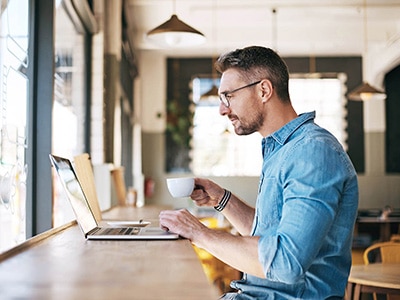 Man drinking coffee and readin...