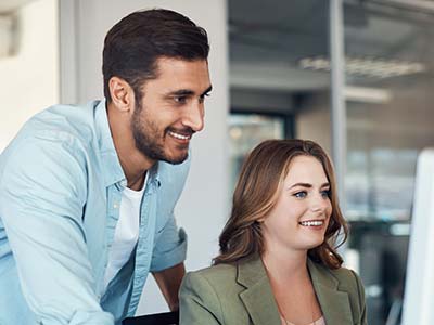 Two women talking while one points to a computer screen
