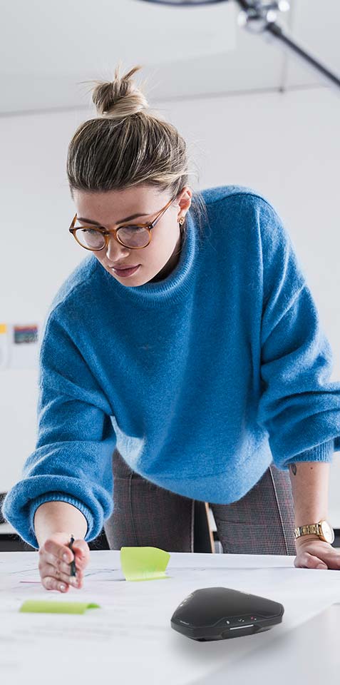 Woman talking on conference phone.