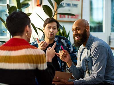 Three coworkers sitting and talking about a project together