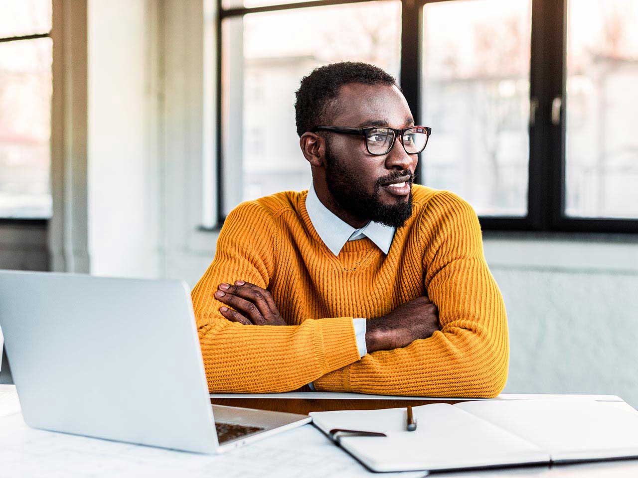 Smiling businessman with crossed arms in office