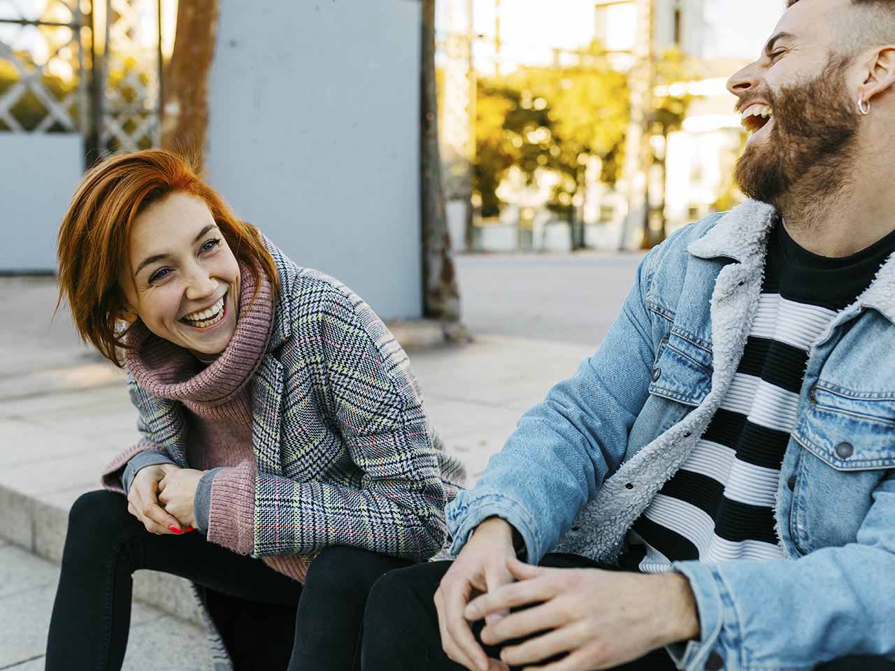 Happy people sitting outdoors laughing