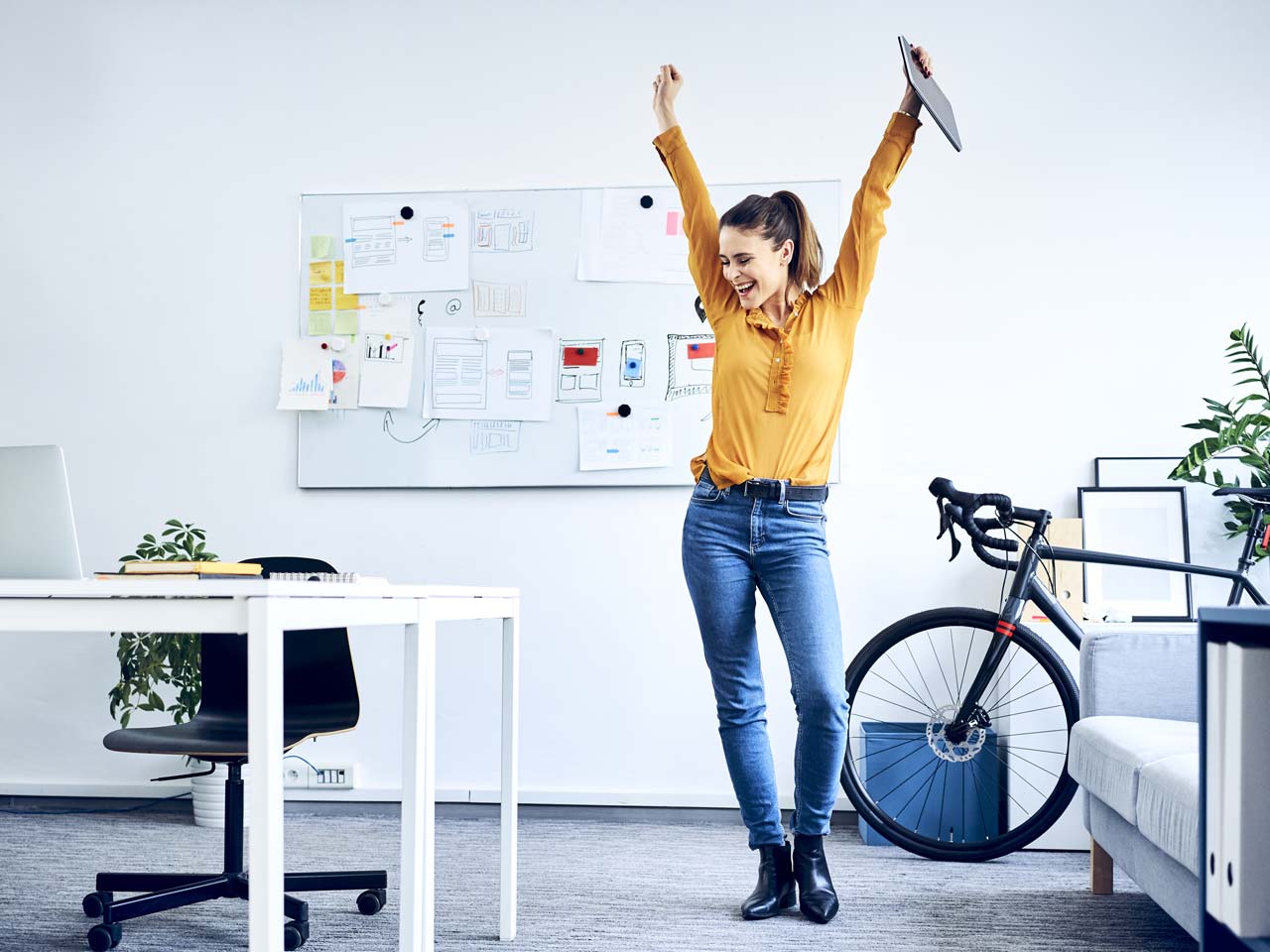 Happy businesswoman cheering in office