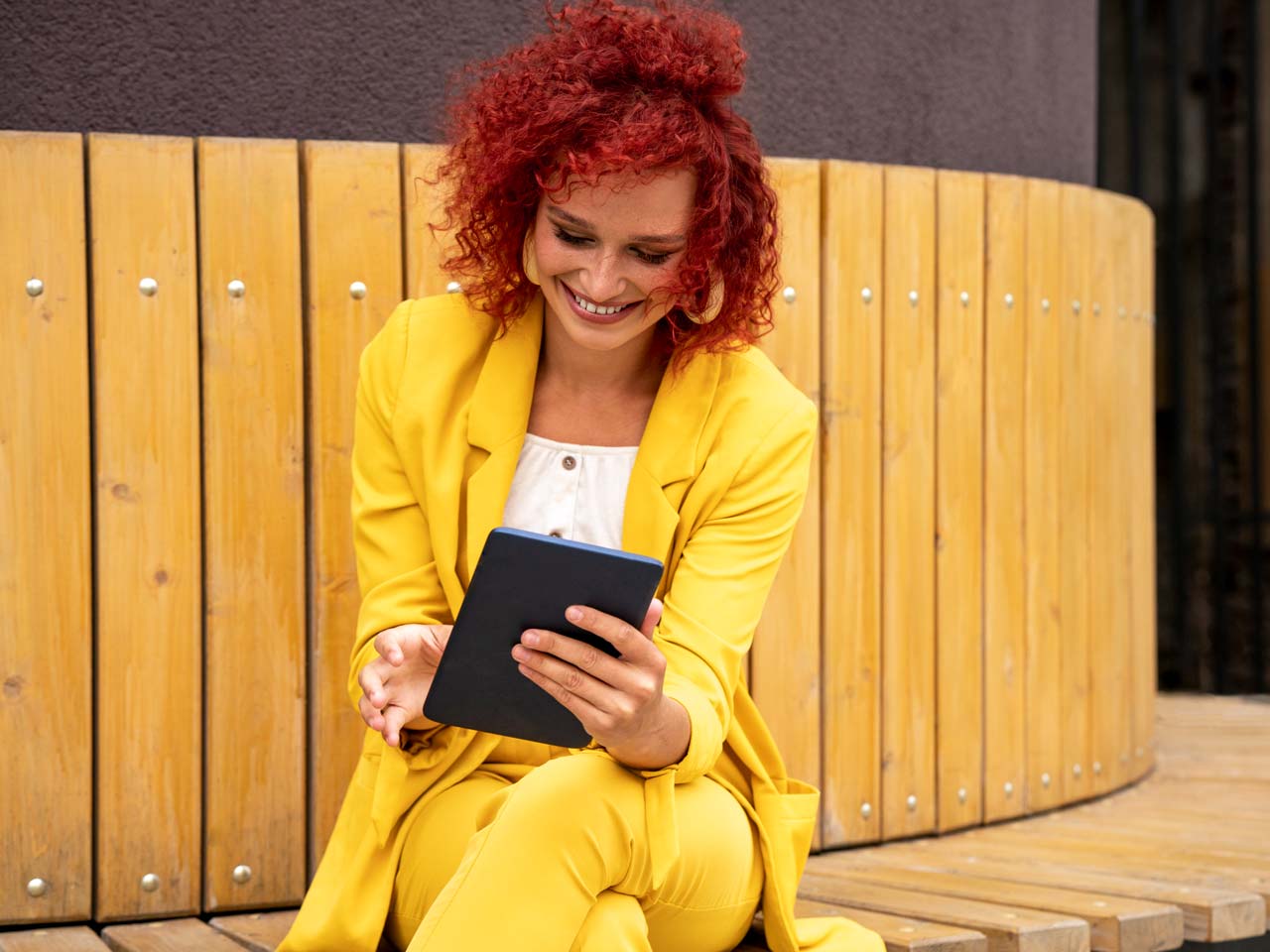 woman on bench using her tablet for a video conference