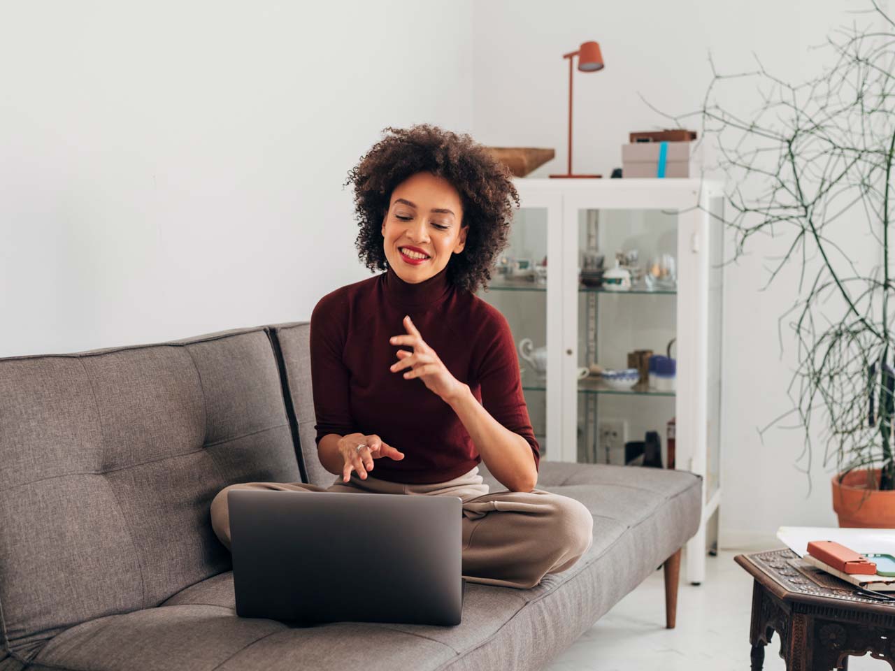 woman on couch using her laptop for a video conference